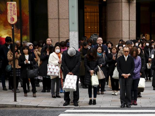 People pray as a the bell tolls to mark the moment the March 11, 2011 earthquake struck Japan, at a junction in Tokyo. (Reuters Photo)