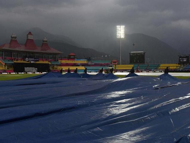 Groundsmen cover pitch due to rains during the T20 World Cup match between Oman and Netherlands in Dharamshala. (PTI Photo)