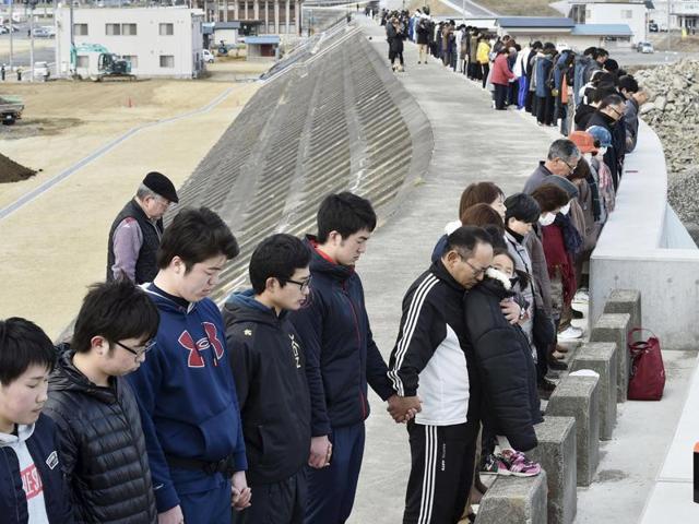 People observe a moment of silence at 2:46pm(0546 GMT) atop of a seawall, at Taro district in Miyako, Japan. (Reuters Photo)