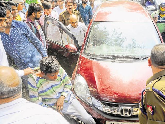 Passersby caught hold of 22-year-old Pankaj Kumar after he shot Rakesh Awasthi and tried to steal his laptop bag from his car on Thursday. (Burhaan Kinu/HT Photo) Passersby caught hold of 22-year-old Pankaj Kumar after he shot Rakesh Awasthi and tried to steal his laptop bag from his car on Thursday. (Burhaan Kinu/HT Photo)