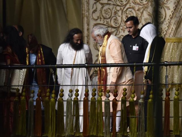 Prime Minister Narendra Modi and Sri Sri Ravi Shankar share a few words before the PM addresses the crowd at the WCF. (Virendra Singh Gosain/HT Photo) 