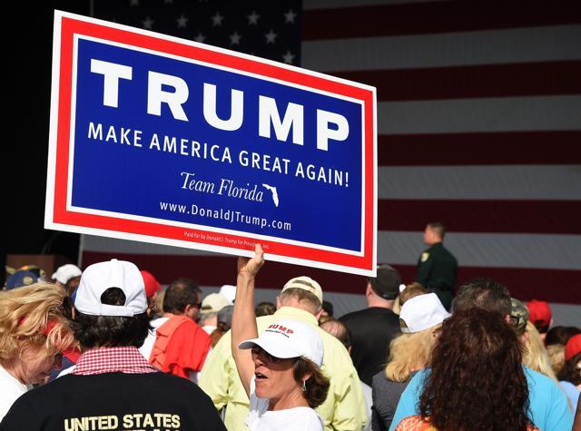 Trump supporters hold signs as they enter the venue prior to a rally for Republican presidential candidate Donald Trump. (AFP) Trump supporters hold signs as they enter the venue prior to a rally for Republican presidential candidate Donald Trump. (AFP)