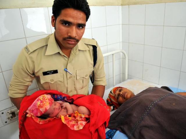 Constable Yogesh Dabe with Durga Kerasiya and her newborn baby on Monday.(Shankar Mourya/ HT photo)