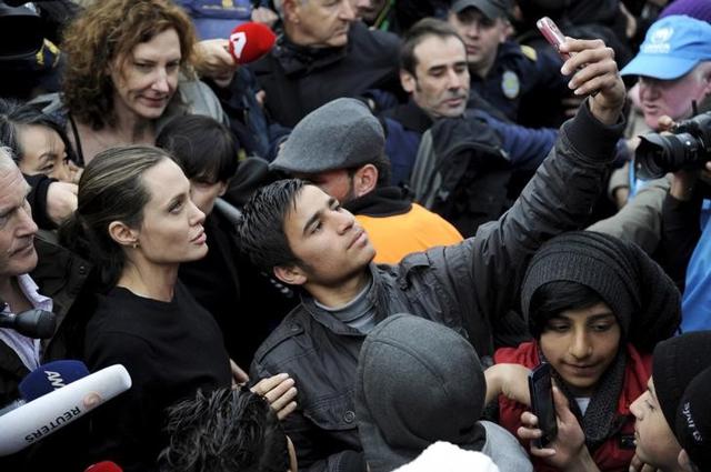 A refugee takes a selfie with Jolie during her visit at the port of Piraeus, near Athens, Greece. A refugee takes a selfie with Jolie during her visit at the port of Piraeus, near Athens, Greece.