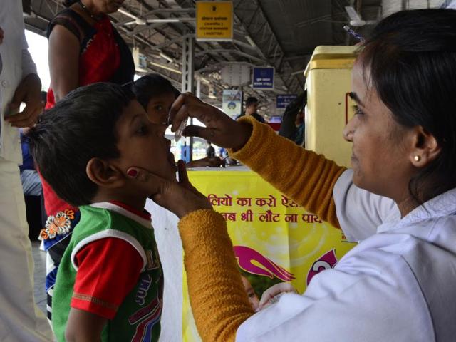 A health worker administers polio drops to a kid at a railway station in Bhopal.(Mujeeb Faruqui/Hindustan Times)