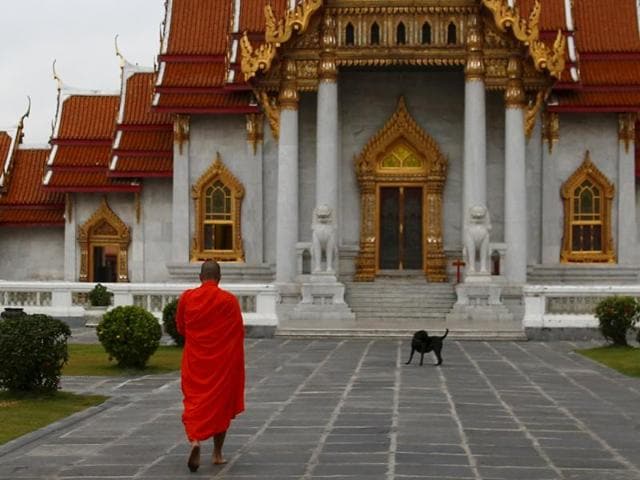 A Buddhist monk enters a temple after receiving food early morning in Bangkok. A Thai gardener who stole precious gems from a Saudi palace in 1989 became a monk on Thursday.(Reuters file for representation)