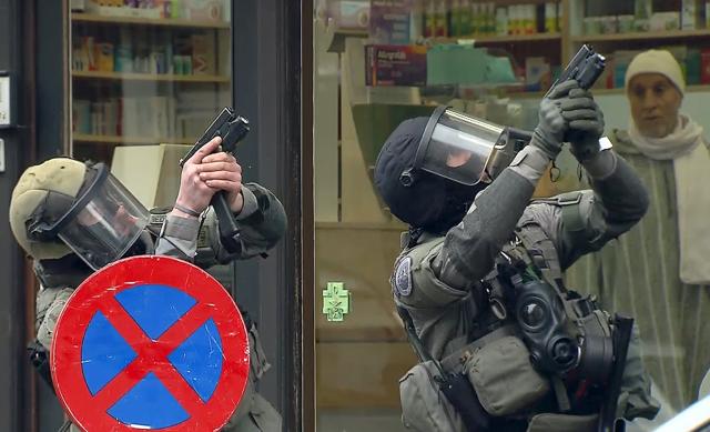 Armed Belgian police secure the area, in this still image taken from video, upon their arrival in Molenbeeck, near Brussels. (REUTERS) Armed Belgian police secure the area, in this still image taken from video, upon their arrival in Molenbeeck, near Brussels. (REUTERS)