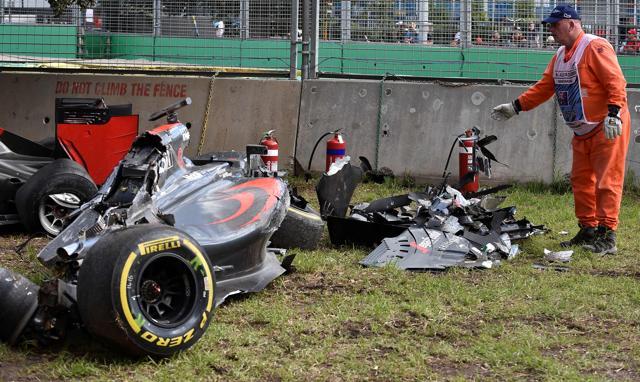 A track marshall drops pieces of detached wreckage of the McLaren Honda car of Spanish driver Fernando Alonso. (AFP Photo)