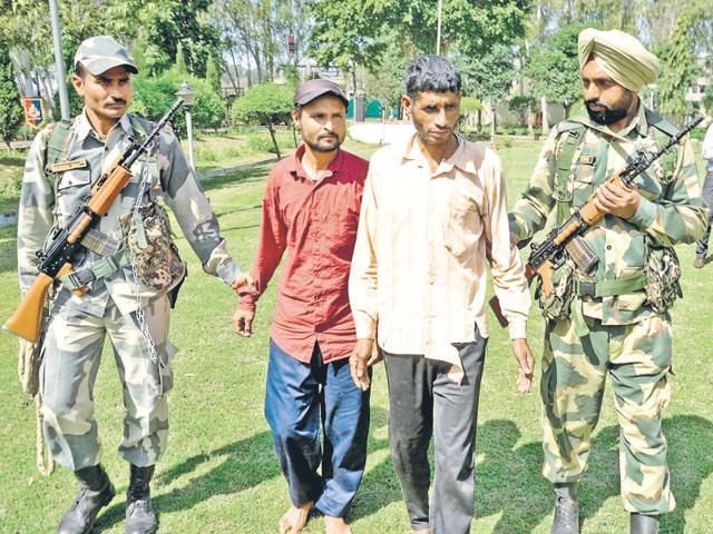 BSF personnel with the accused duo at Ramtirath, about 15 km from Amritsar, on Sunday. (Sameer Sehgal/HT Photo) BSF personnel with the accused duo at Ramtirath, about 15 km from Amritsar, on Sunday. (Sameer Sehgal/HT Photo)