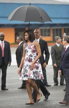 US President Barack Obama holds an umbrella for first lady Michelle Obama as they walk across the tarmac upon their arrival at Jose Marti International Airport in Havana. (AP Photo) US President Barack Obama holds an umbrella for first lady Michelle Obama as they walk across the tarmac upon their arrival at Jose Marti International Airport in Havana. (AP Photo)