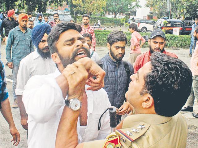 A cop trying to disperse students protesting on the Panjab University campus.(HT Photo) A cop trying to disperse students protesting on the Panjab University campus.(HT Photo)