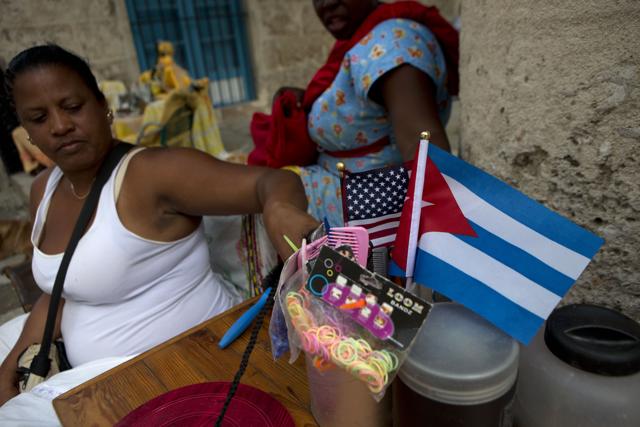 Hair braider Dona Navarrete, whose stand is decorated with an American, and a Cuban national flag, adjusts her combs as she waits for clients in Old Havana. (AP Photo) Hair braider Dona Navarrete, whose stand is decorated with an American, and a Cuban national flag, adjusts her combs as she waits for clients in Old Havana. (AP Photo)