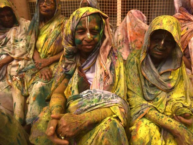Widows smeared in Gulal rest after taking part in Holi celebrations organized by non-governmental organization, Sulabh International at Gopinath temple at Vrindavan. (Ajay Aggarwal/HT Photo)