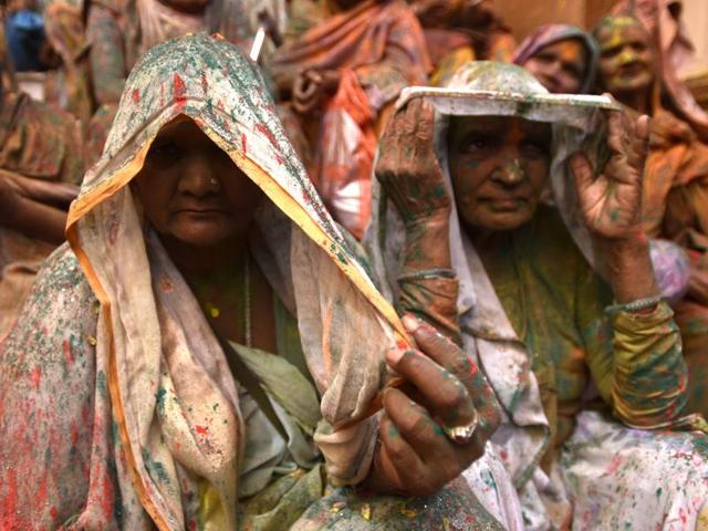 Widows rest after participating in Holi celebrations. In many parts of India widows are barred from celebrating the festival but women at the shelter for widows broke the bygone norm and enjoyed the festival. (Ajay Aggarwal/HT Photo)
