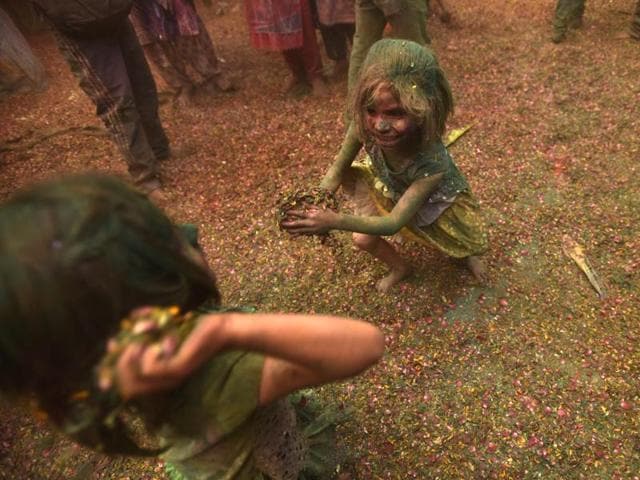 Children throw petals and gulal at each other as widows celebrate HOli in Gopinath Temple in Vrindavan. (Ajay Aggarwal/HT Photo)