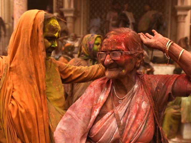 Widows smeared in Gulal rest after taking part in Holi celebrations organized by non-governmental organization, Sulabh International at Gopinath temple at Vrindavan. In many parts of India widows are barred from celebrating the festival but women at the shelter for widows broke the bygone norm and enjoyed the festival. (Ajay Aggarwal/HT Photo)