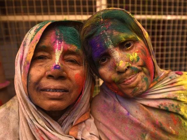 Widows smeared in Gulal rest after taking part in Holi celebrations organized by non-governmental organization, Sulabh International at Gopinath temple at Vrindavan. In many parts of India widows are barred from celebrating the festival but women at the shelter for widows broke the bygone norm and enjoyed the festival. (Ajay Aggarwal/HT Photo)