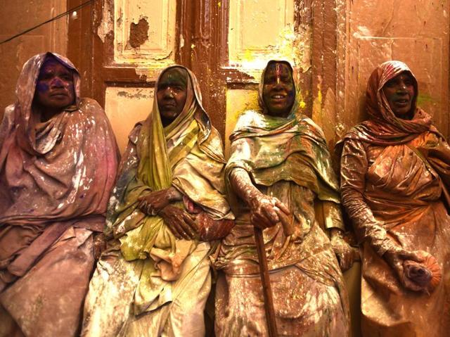 Widows smeared in Gulal rest after taking part in Holi celebrations organized by non-governmental organization, Sulabh International at Gopinath temple at Vrindavan. In many parts of India widows are barred from celebrating the festival but women at the shelter for widows broke the bygone norm and enjoyed the festival. (Ajay Aggarwal/HT Photo)