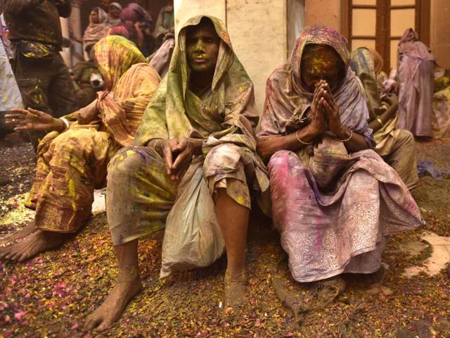 Widows smeared in Gulal rest after taking part in Holi celebrations organized by non-governmental organization, Sulabh International at Gopinath temple at Vrindavan. In many parts of India widows are barred from celebrating the festival but women at the shelter for widows broke the bygone norm and enjoyed the festival. (Ajay Aggarwal/HT Photo)