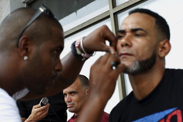 Cuban migrants cut their hair and shave their beard at an old hotel used as a provisional shelter in Paso Canoas, at the border with Costa Rica. (REUTERS) Cuban migrants cut their hair and shave their beard at an old hotel used as a provisional shelter in Paso Canoas, at the border with Costa Rica. (REUTERS)