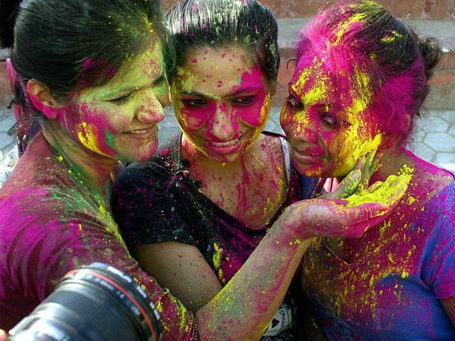 Young girls smear the faces of their friends with vibrant colors ahead of Holi, in Bhopal on Wednesday. (Bidesh Manna/HT photo) Young girls smear the faces of their friends with vibrant colors ahead of Holi, in Bhopal on Wednesday. (Bidesh Manna/HT photo)
