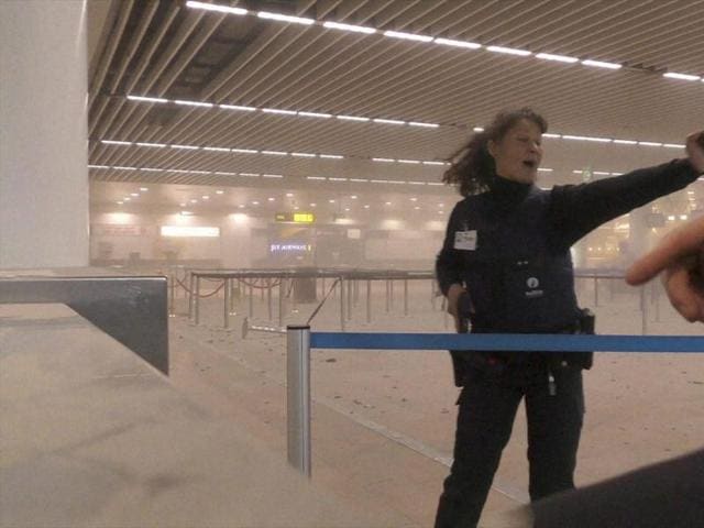 In this photo provided by Ralph Usbeck a police officers directs passengers in a smoke filled terminal at Brussels Airport, in Brussels after explosions. (AP) In this photo provided by Ralph Usbeck a police officers directs passengers in a smoke filled terminal at Brussels Airport, in Brussels after explosions. (AP)