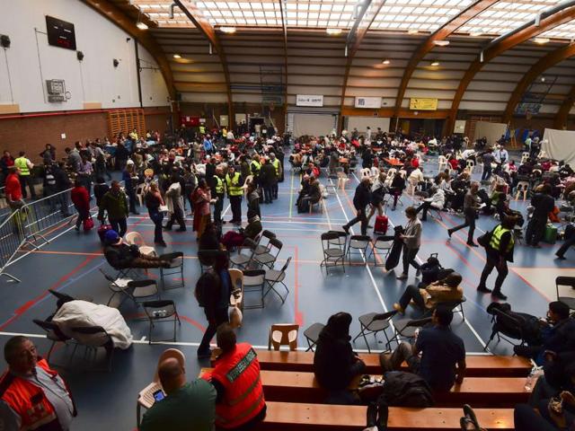 Travellers who were evacuated from Brussels airport take shelter at a sports complex in Zaventem following blasts. (AFP) Travellers who were evacuated from Brussels airport take shelter at a sports complex in Zaventem following blasts. (AFP)