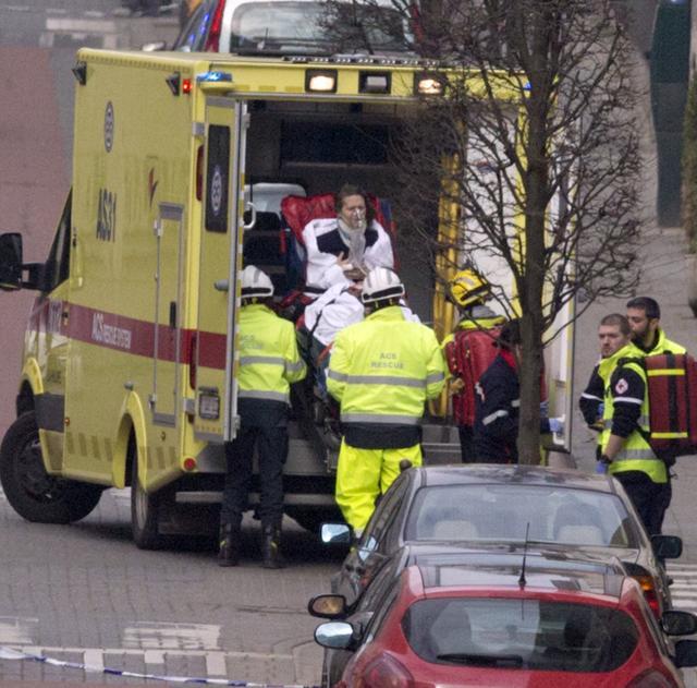 Emergency services personnel assist a woman after an explosion hit a metro station in Brussels on Tuesday. (AP) Emergency services personnel assist a woman after an explosion hit a metro station in Brussels on Tuesday. (AP)