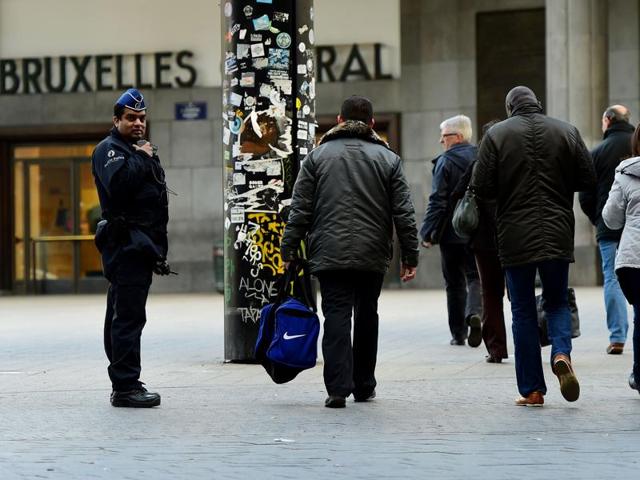 A Belgian police officer looks on as people walk past during an operation to limit the number of people allowed into the central station in Brussels. (AFP) A Belgian police officer looks on as people walk past during an operation to limit the number of people allowed into the central station in Brussels. (AFP)