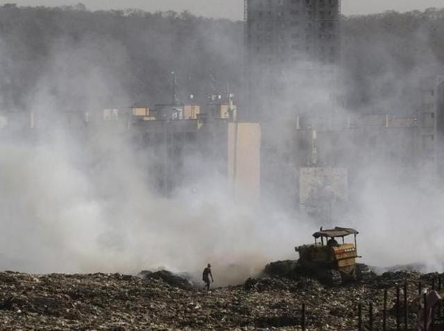 A ragpicker collects recyclable material as smoke billows from the burning garbage at the Deonar dumping ground in Mumbai. (Bachchan Kumar/HT Photo) A ragpicker collects recyclable material as smoke billows from the burning garbage at the Deonar dumping ground in Mumbai. (Bachchan Kumar/HT Photo)