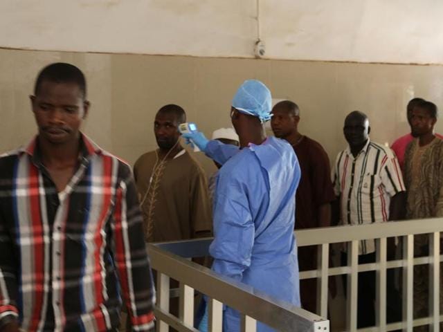 A health worker takes the temperature of people to see if they might be infected by the Ebola virus at a hospital in Conakry, Guinea. (AP) A health worker takes the temperature of people to see if they might be infected by the Ebola virus at a hospital in Conakry, Guinea. (AP)