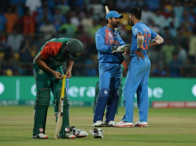 India captain Mahendra Singh Dhoni interacts with Hardik Pandya during the last over of the World T20 cricket match against Bangladesh at the Chinnaswamy Stadium in Bangaluru.(AFP)