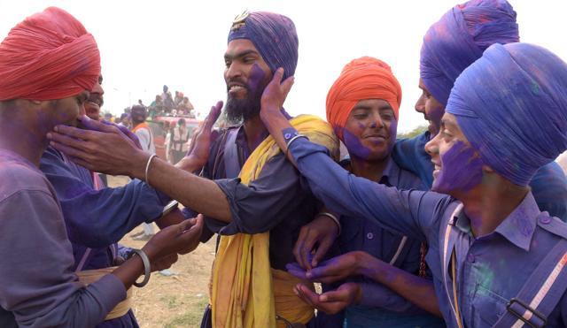 Nihangs applying colours on each other’s faces. (Sanjeev Sharma/HT )