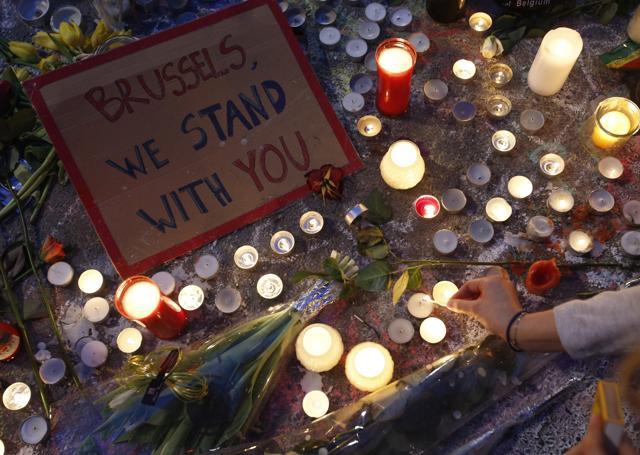 A woman lights a candle among the tributes to the victims of the recent attacks in Brussels, placed in Place de la Bourse. (AP Photo) A woman lights a candle among the tributes to the victims of the recent attacks in Brussels, placed in Place de la Bourse. (AP Photo)