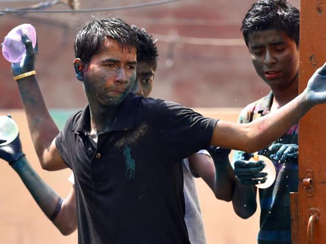 People celebrating Holi at Vinod Nagar. (Virendra Singh Gosain/HT Photo )