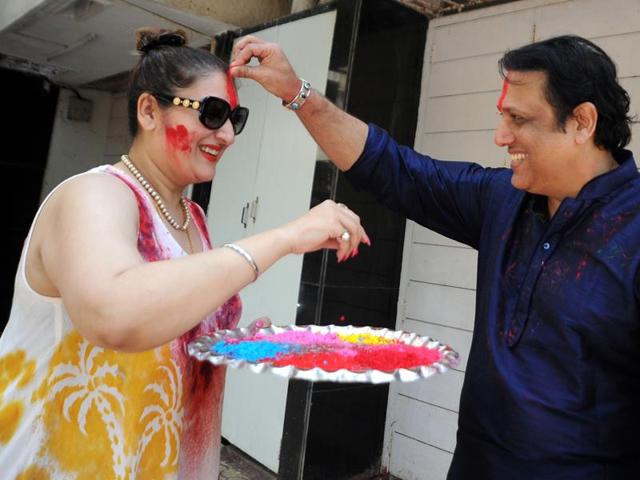 Govinda places colour on the forehead of his wife Sunita Ahuja during their Holi celebration. (AFP)
