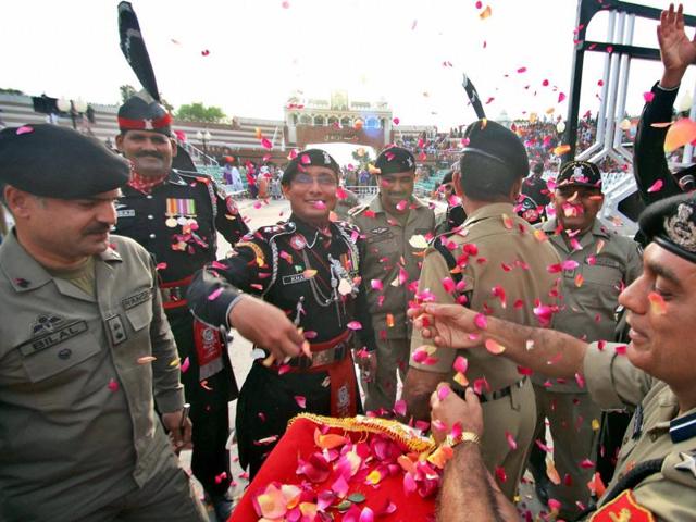 BSF personnel shower flower petals on Pakistan Rangers at the Zero line, Attari international border.(PTI Photo)