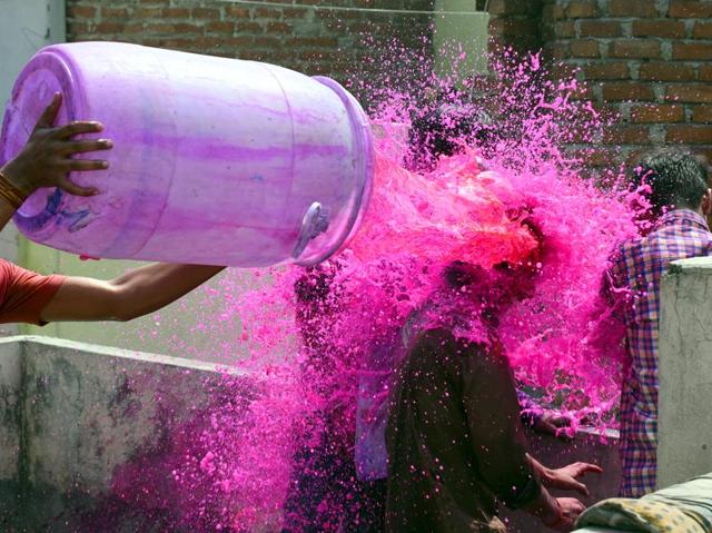 People seen playing with colours during Holi Festival at Gandhi Nagar. (Sonu Mehta/HT Photo)