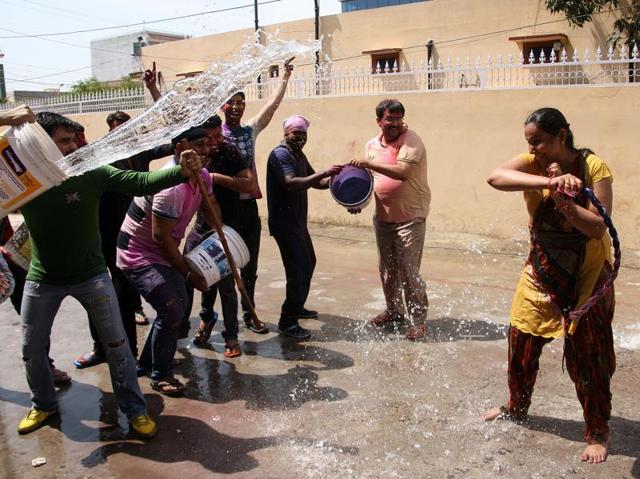 People in Rohtak celebrating Holi, with happiness and enthusiasm. Residents of Vikas Nagar splashing water and colours on each other. (Manoj Dhaka/HT Photo )