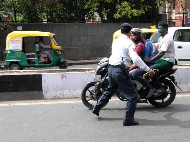 Delhi Traffic Police catching the motorcyclist who were braking the law while celebrating Holi in the capital on Thursday. (HT Photo)