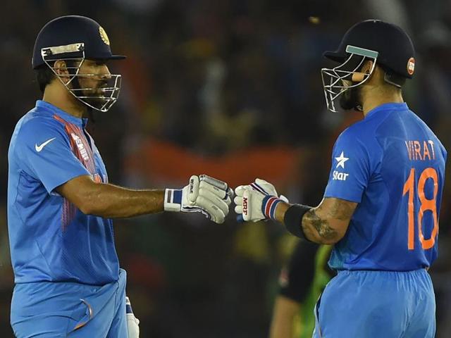 Kohli (R) exchanges a fist pump with captain Mahendra Singh Dhoni. With 39 required off the last 3 overs, the duo hit 39 in 13 balls, with 7 fours and one six to overhaul the target.   (AFP) 