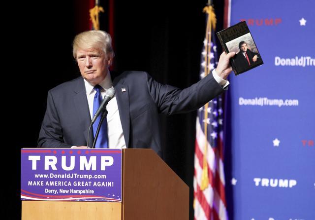 Republican presidential candidate Donald Trump holds up a copy of his 1987 book, "Trump: The Art of the Deal" during his campaign. (AP file photo)