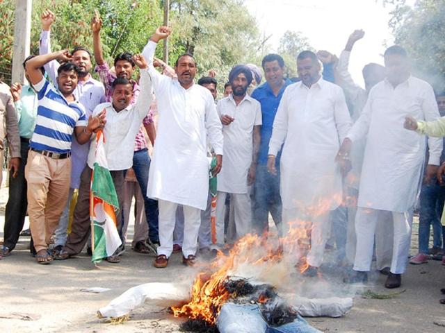 Congress councillors burning an effigy of municipal commissioner Anil Garg in Bathinda on Saturday. (HT Photo)
