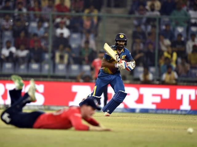 Chamara Kapugedera watches his shot as an England fielder dives in an attempt to stop it. (Sanjeev Verma/HT Photo) 
