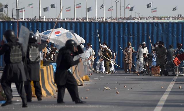 Riot police carrying batons and shields fired tear gas to try to prevent protestors pushing closer to Islamabad’s centre. (AP) Riot police carrying batons and shields fired tear gas to try to prevent protestors pushing closer to Islamabad’s centre. (AP)
