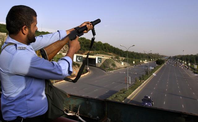 A Pakistani policeman fires tear gas to stop protesters from marching towards the parliament building in Islamabad, Sunday, March 27, 2016. (AP) A Pakistani policeman fires tear gas to stop protesters from marching towards the parliament building in Islamabad, Sunday, March 27, 2016. (AP)