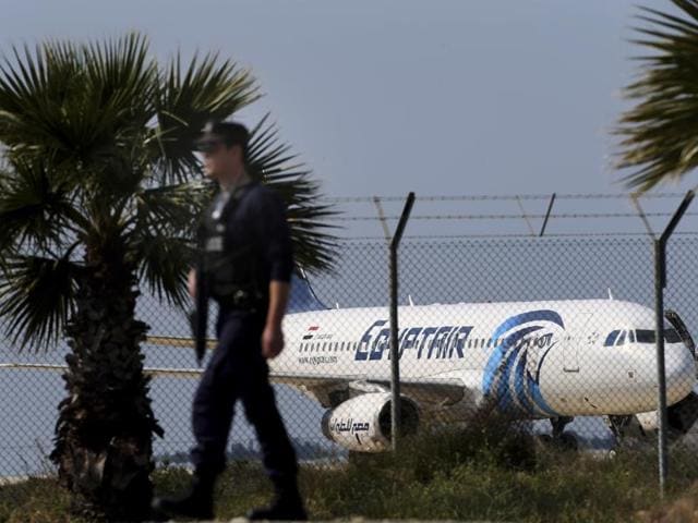 A police officer patrols outside the airport as an hijacked aircraft of EgyptAir is seen after landing at Larnaca Airport in Cyprus Tuesday, March 29, 2016. (AP Photo) A police officer patrols outside the airport as an hijacked aircraft of EgyptAir is seen after landing at Larnaca Airport in Cyprus Tuesday, March 29, 2016. (AP Photo)