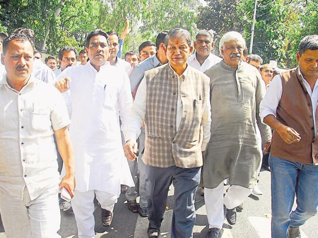 Former CM Harish Rawat, with his supporters, leaves the Governor’s house on Monday. (Vinay Santosh Kumar/HT Photo)