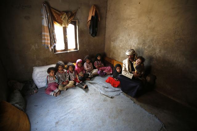 Faisal Ahmed, whose infant son, Udai Faisal, died of severe acute malnutrition, sits with his nine remaining children at his house in Hazyaz village on the southern outskirts of Sanaa, Yemen. (AP) Faisal Ahmed, whose infant son, Udai Faisal, died of severe acute malnutrition, sits with his nine remaining children at his house in Hazyaz village on the southern outskirts of Sanaa, Yemen. (AP)