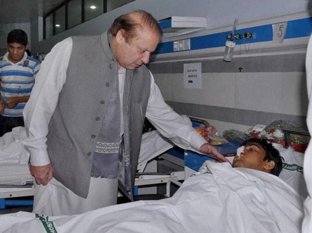 Pakistan's Prime Minister Nawaz Sharif talks to an injured victim of Sunday's suicide bombing during his visit to a local hospital in Lahore.(AP)
